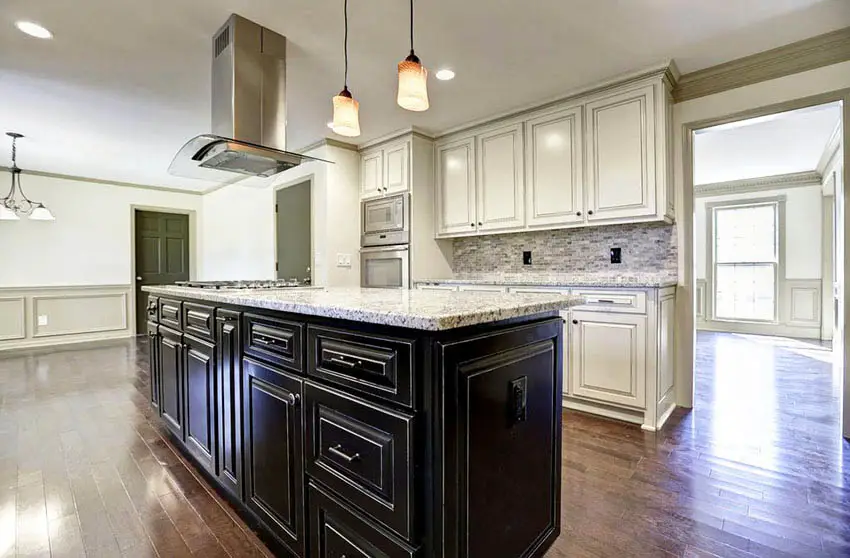 Kitchen with distressed black cabinet island and white main cabinets