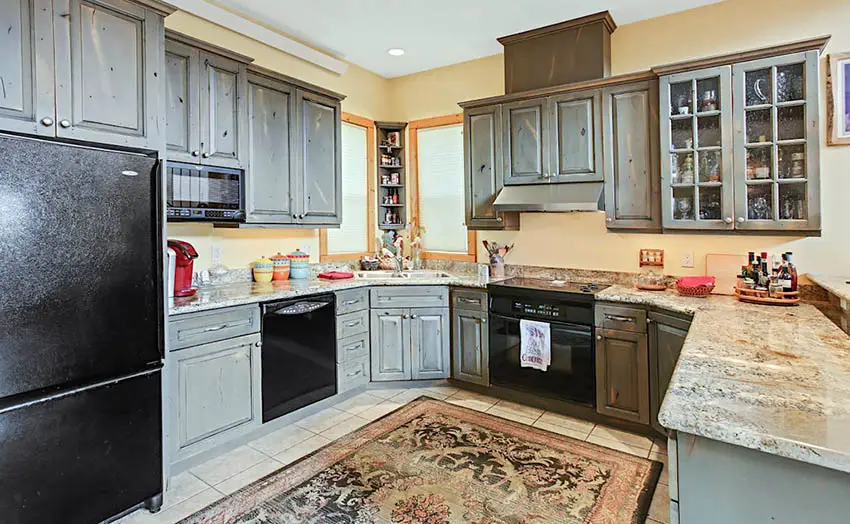 Kitchen with distressed grey cabinets and white granite countertops