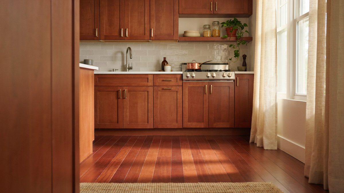 Cherry cabinet kitchen with glossy reddish jatoba floorboards and linen curtains