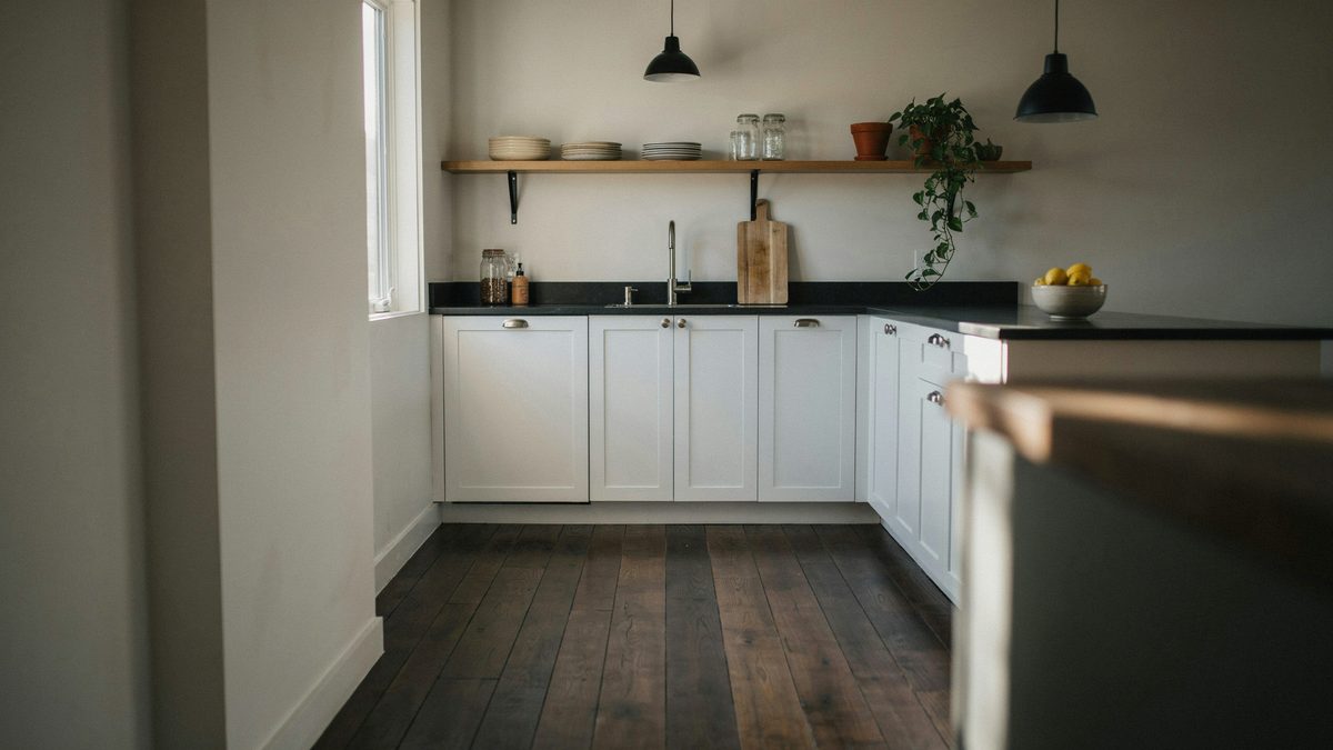 Moody galley kitchen with black counters above dark stained maple boards