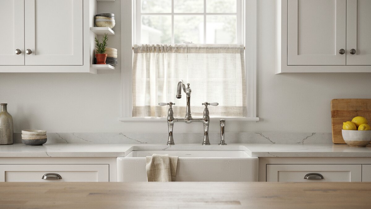Two handle bridge faucet in polished chrome above white farmhouse sink