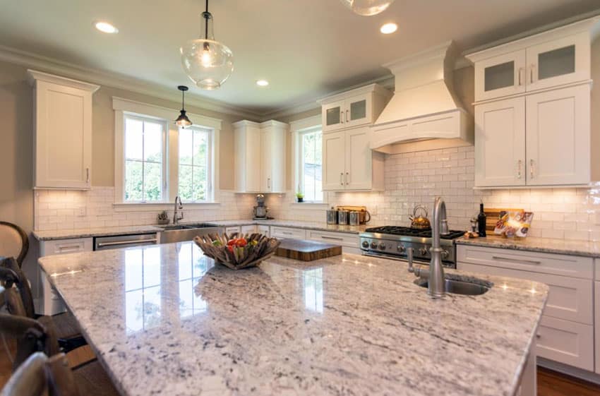 Kitchen with white cabinets and bianco romano granite countertops