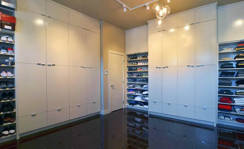 Large modern walk in closet with glossy white cabinets
