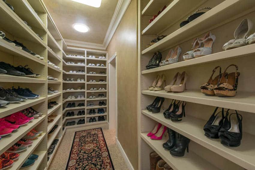 Closet with textured walls of open shelves and carpet runner