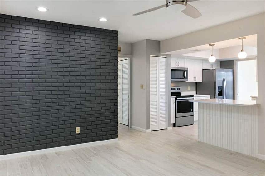Basement room with black painted brick accent wall
