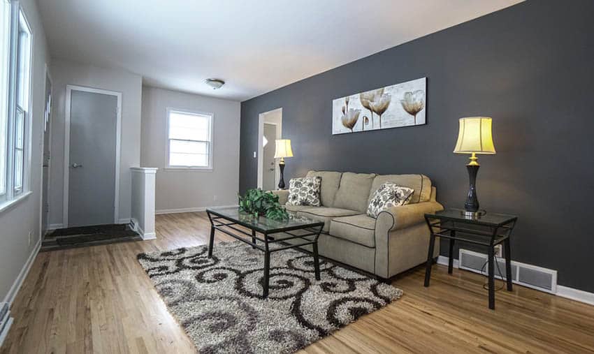 Small room with one black painted wall and laminate flooring