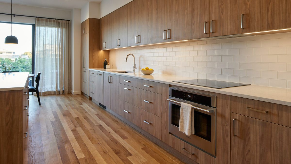 Wood grain laminate cabinets with under cabinet lighting and subway tile
