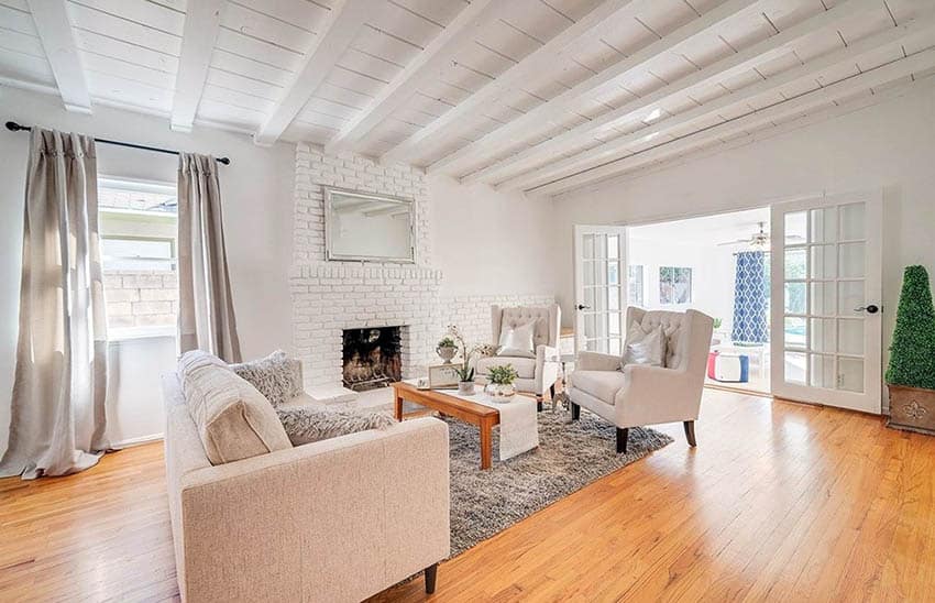 Shabby chic living room with white washed fireplace and wood flooring