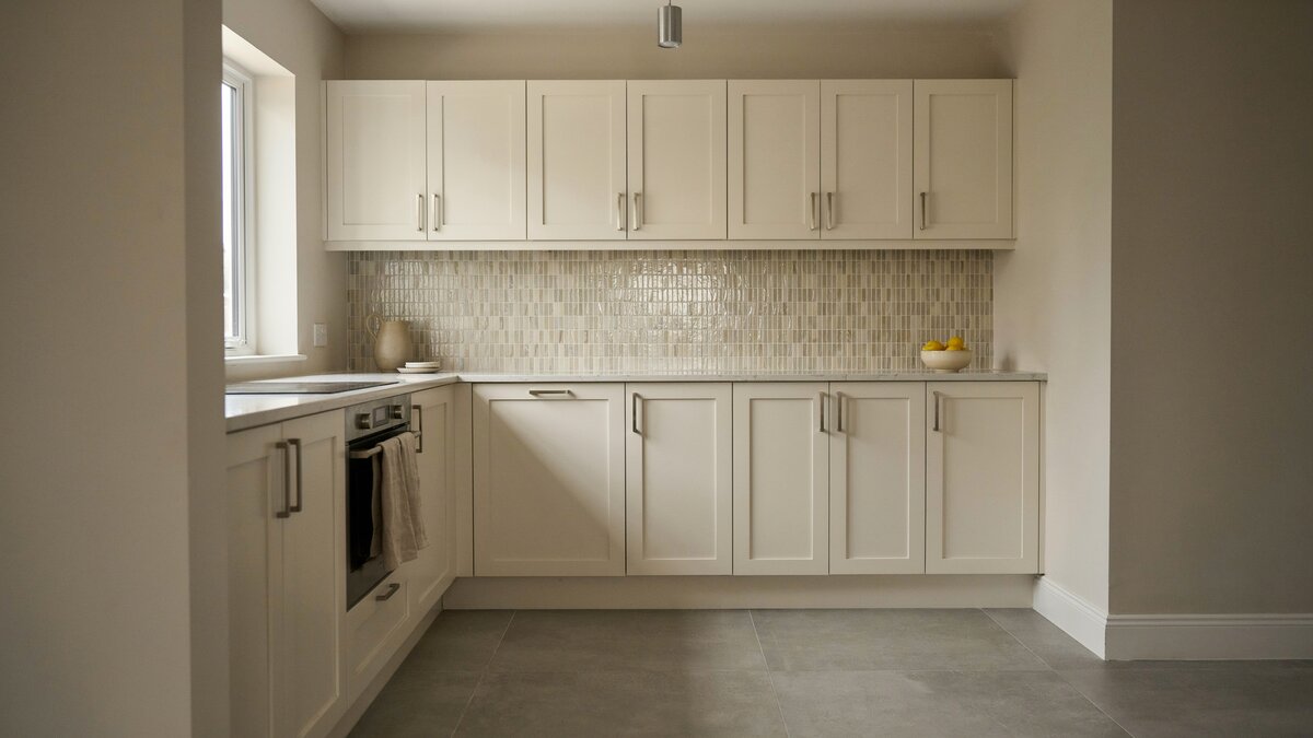 Small kitchen with mosaic tile backsplash, chrome pulls and a pale gray tile floor