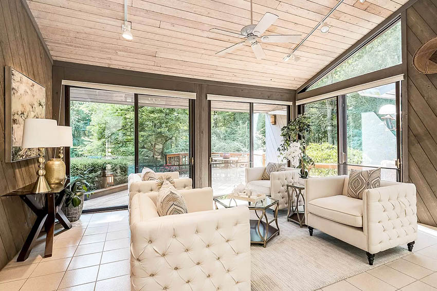 Sunroom with wood paneling shiplap ceiling plush tufted furniture