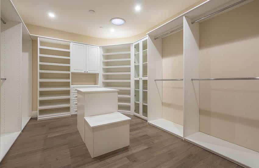 Traditional closet with two level island and glass door cabinets