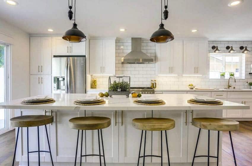 Transitional kitchen with white shaker cabinets, subway tile backsplash, quartz countertops and large island
