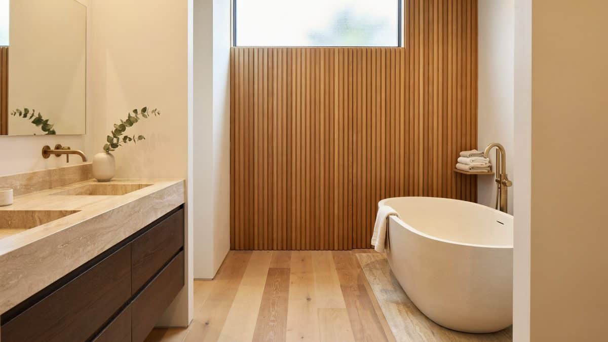 Master bath with travertine vanity top, walnut cabinets and freestanding oval soaking tub