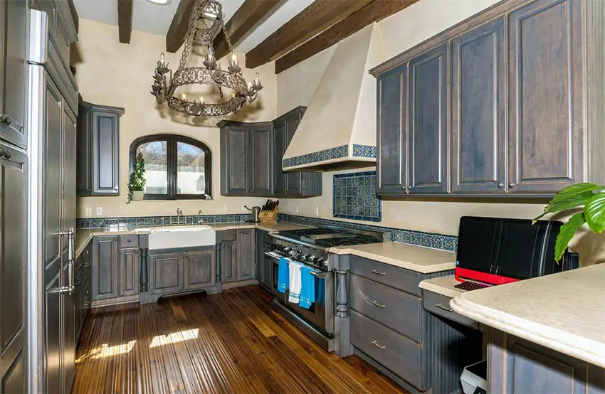 Tuscan kitchen with dark distressed cabinets rustic chandelier and bamboo flooring