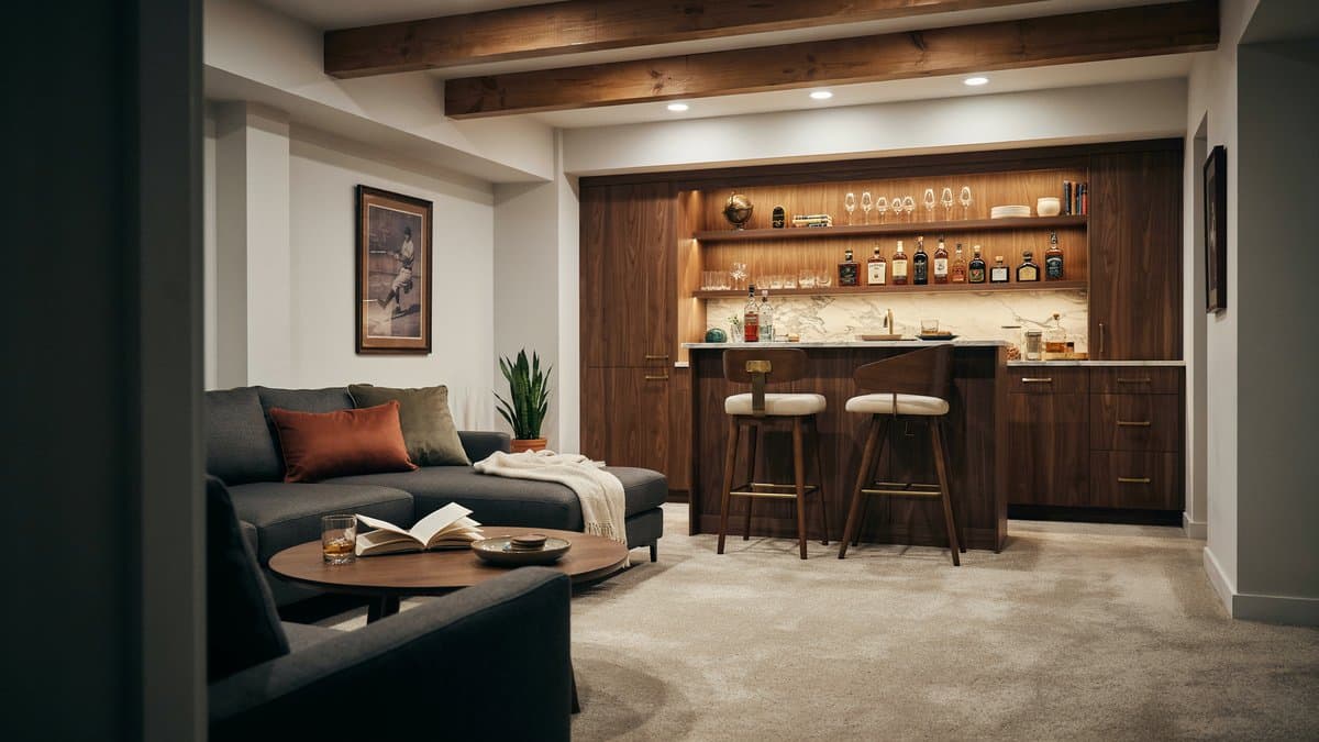 Beige carpet lounge facing a walnut wet bar with two leather stools
