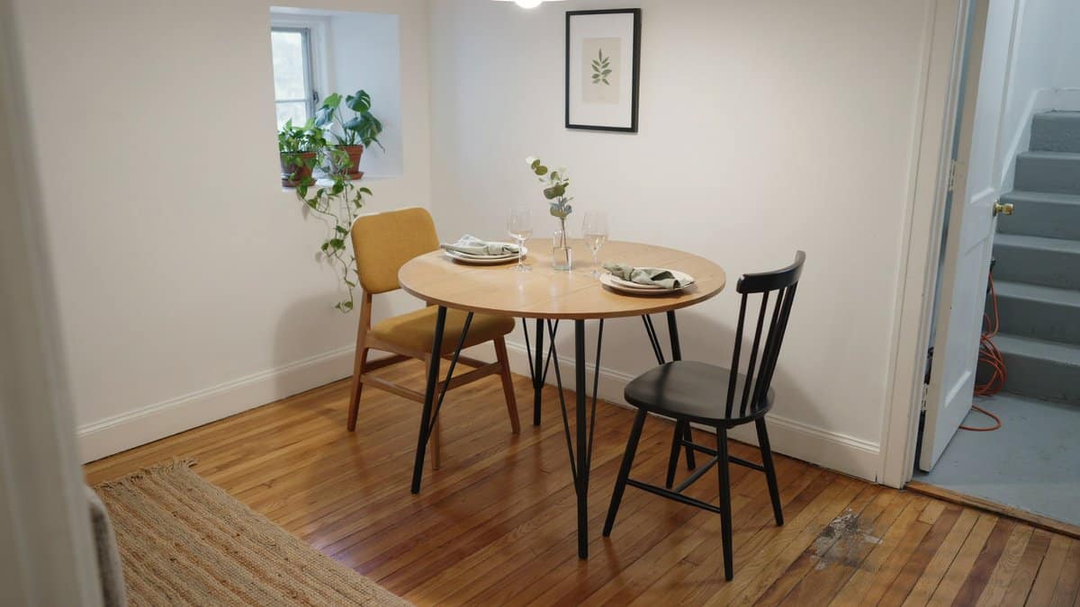 Warm laminate planks in a white walled nook with round dining table