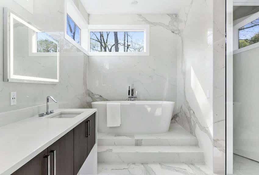 Bathroom with white quartz countertop vanity tub on pedestal