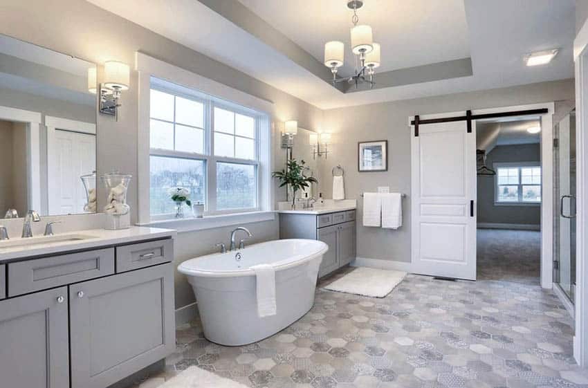 Gorgeous contemporary bathroom with his and hers gray sink vanities & freestanding tub