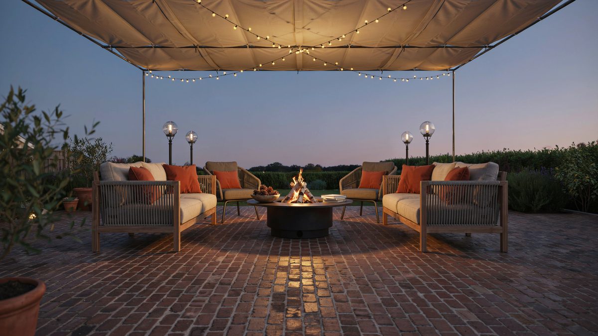 Brick patio under a fabric canopy with fairy lights and a central fire pit