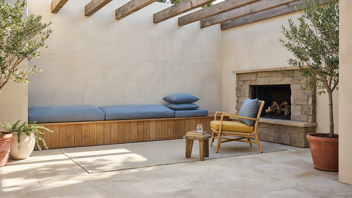 Small pergola patio with built in bench, yellow chair and sky blue cushions