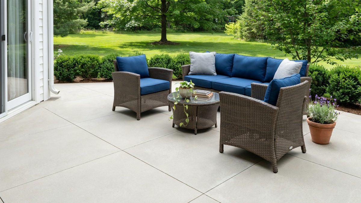 Backyard patio off the house doors with blue cushioned rattan seating