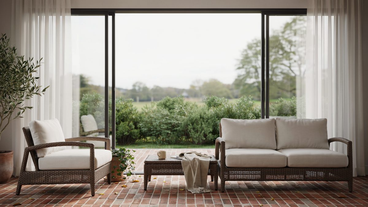 Red brick patio outside picture windows with dark brown rattan furniture