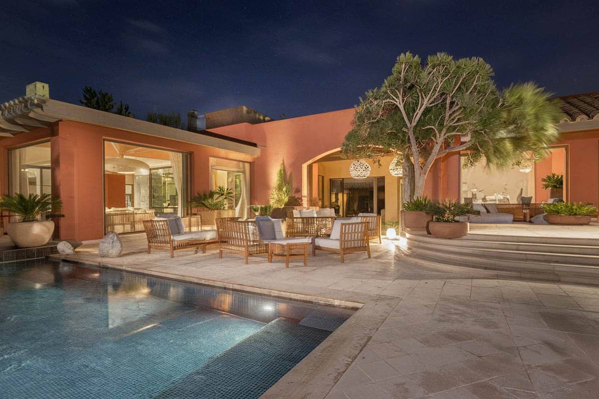 Mediterranean inspired patio with swimming pool and tropical plants