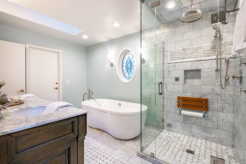 Bathroom with marble tiled shower, multiple shower heads and freestanding freeform tub