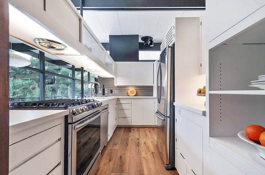 Mid century modern kitchen with white cabinets and pass through peninsula