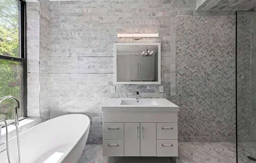 Modern bathroom with single sink marble tile walls and tub
