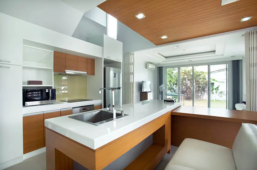 Modern galley kitchen design with island bench seating and corian countertops