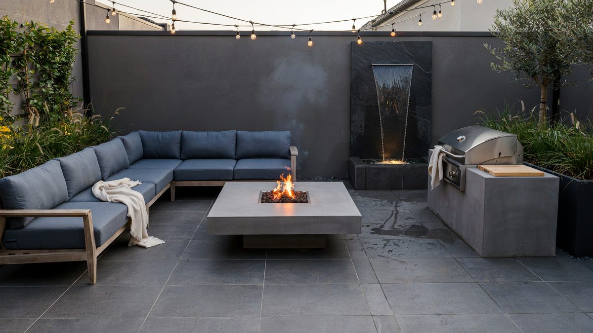 Compact patio with slate blue sofas, coffee table fire pit and grill counter