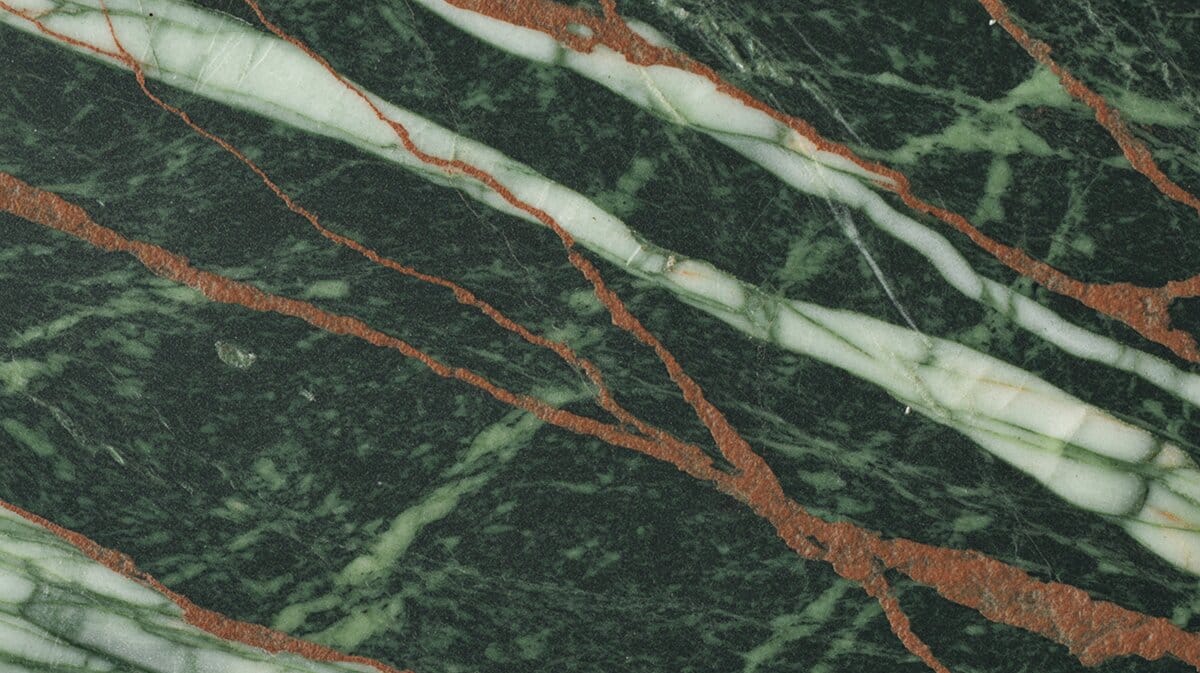 Rainforest Green granite slab with dark forest green base, wide white veining and reddish-orange mineral streaks across the surface