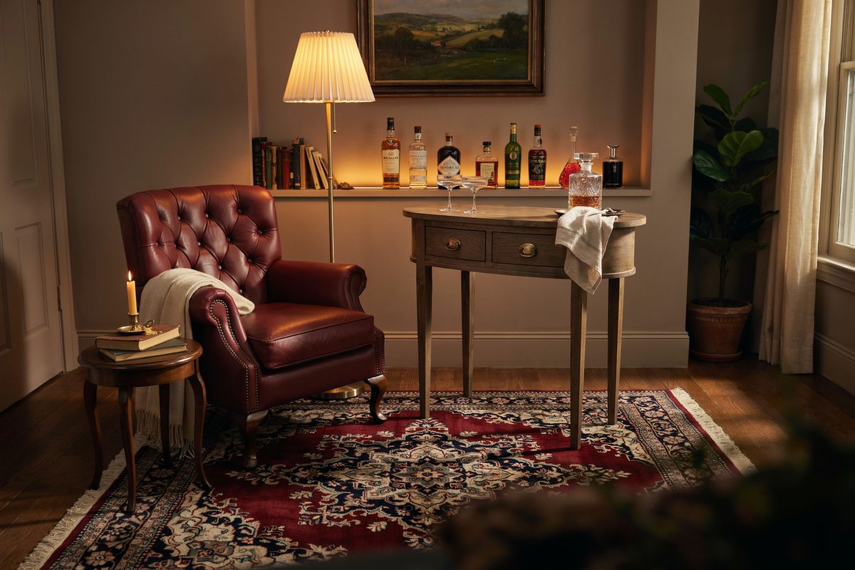 Rustic wood console bar and red leather wing chair under warm lamplight