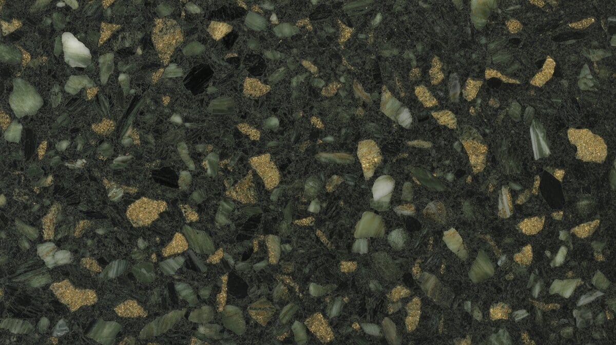Uba Tuba granite close-up showing dark forest green base with scattered gold, white and pale green mineral flecks throughout