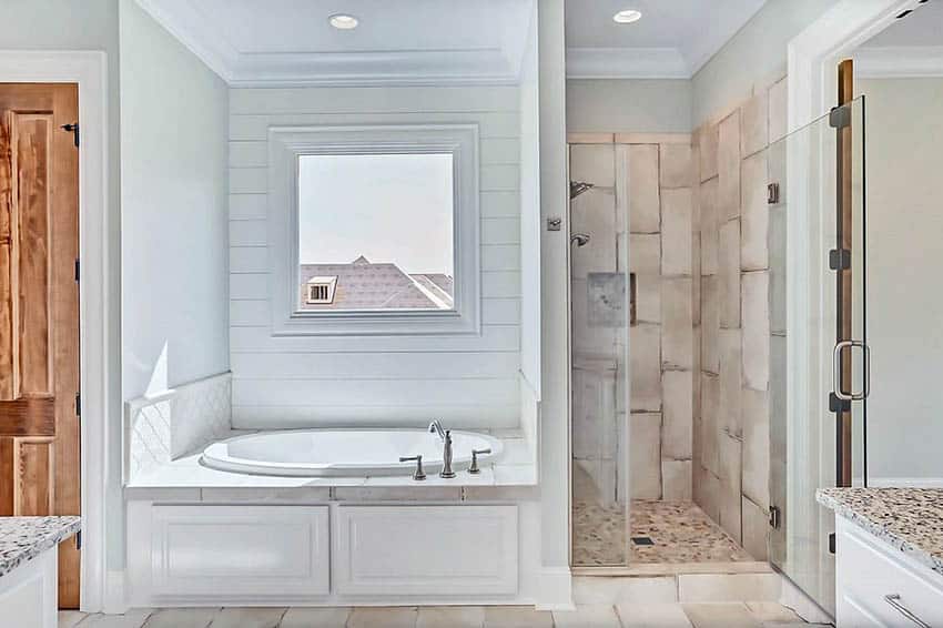 Bathroom with shiplap accent recessed wall with window behind tub