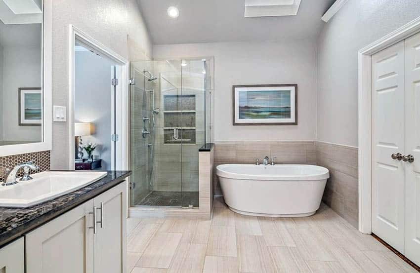 Bathroom with tile wainscoting freestanding tub and porcelain tile floor