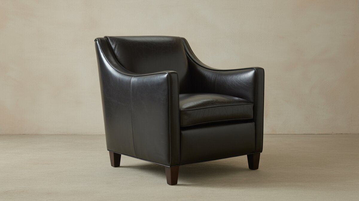 Black leather club chair with low back and dark legs