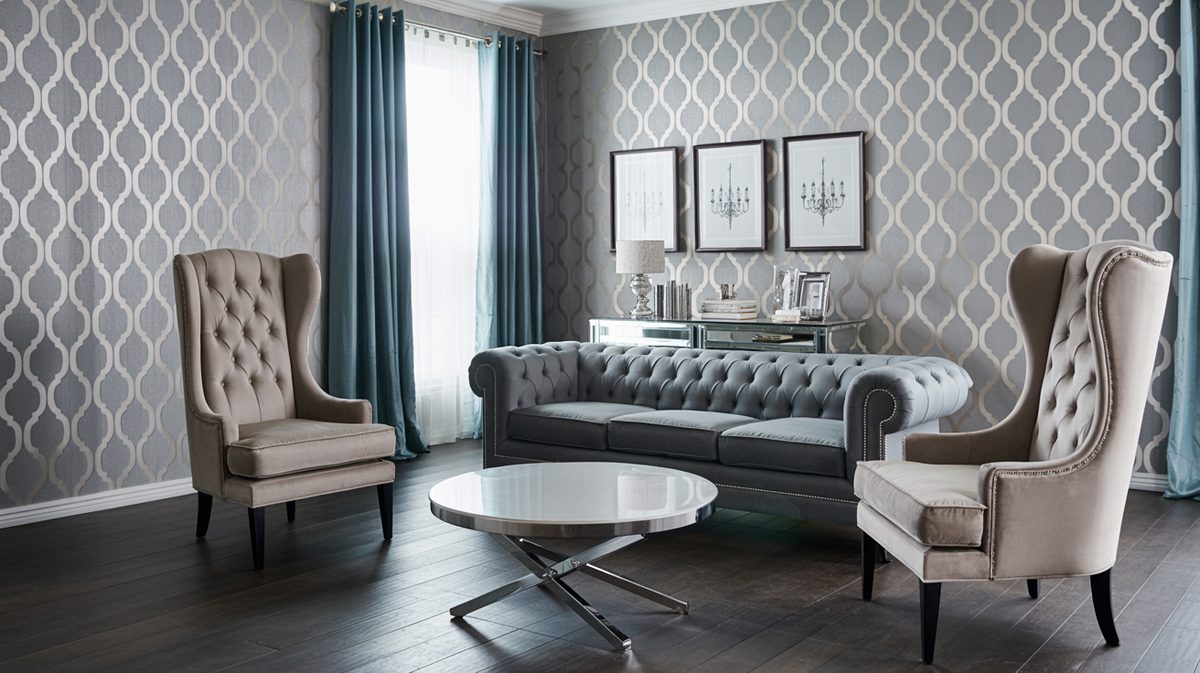 Silver gray trellis patterned wallpaper with dark velvet tufted sofa and beige wingback chairs