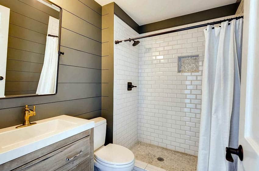 Guest bathroom with olive green shiplap walls white subway tile shower