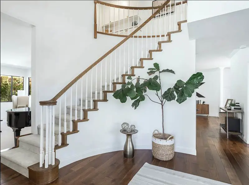 Home entry with white painted railing and wood flooring