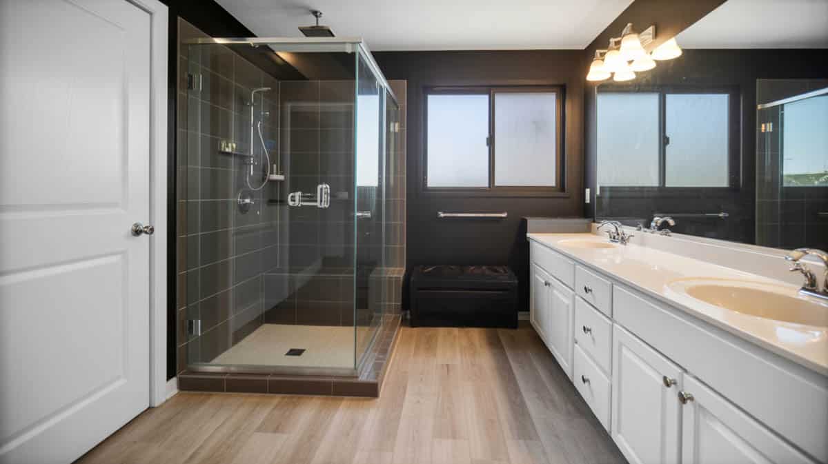 Contemporary master bathroom with matte black tile accent wall in glass shower enclosure and light wood laminate floor