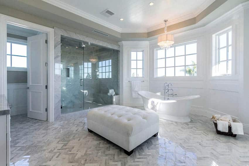 Bathroom with full wall wainscoting, cast iron bathtub and glass shower