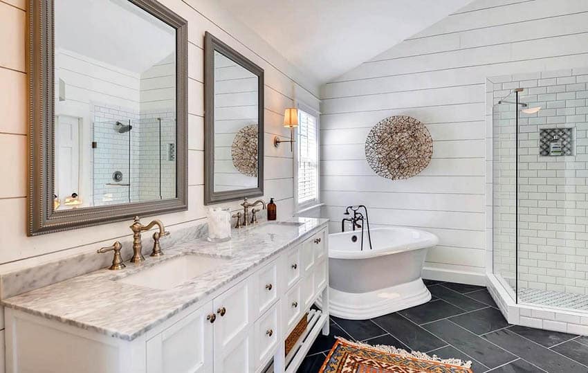 Master bathroom with shiplap walls, pedestal tub and subway tile shower