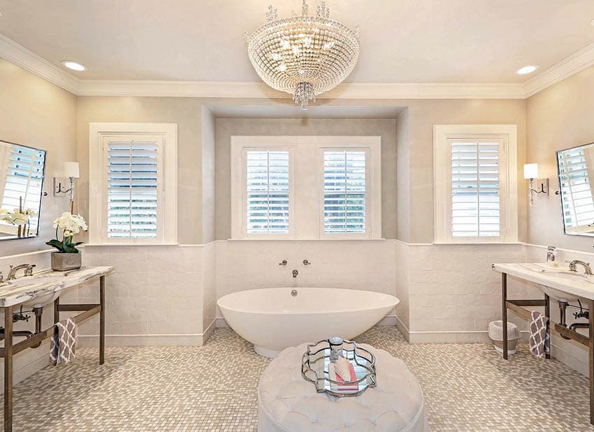 Bathroom with tile wainscoting, mosaic grey and cream floor and chandelier