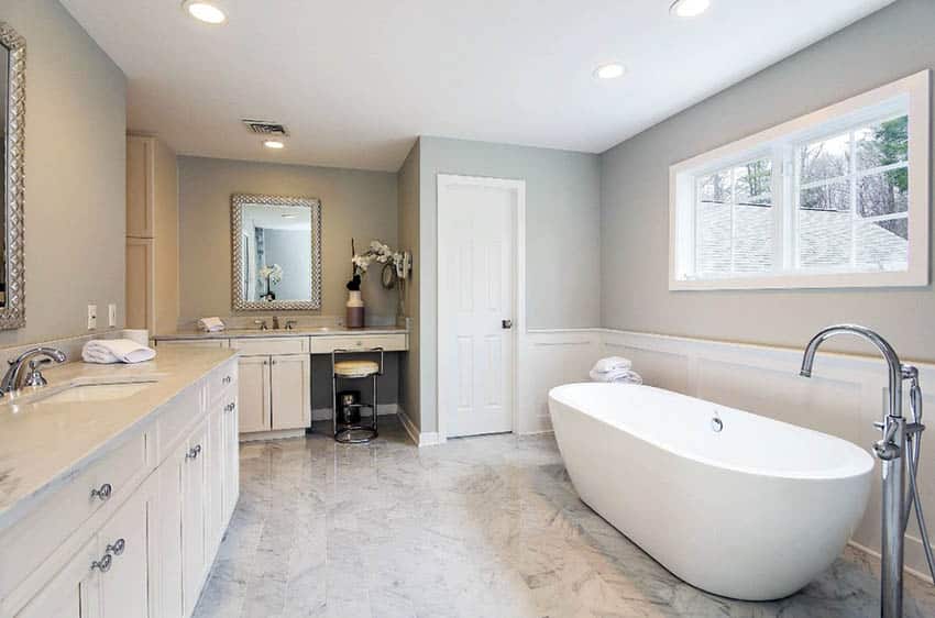 Bathroom with white wainscoting and dual vanities