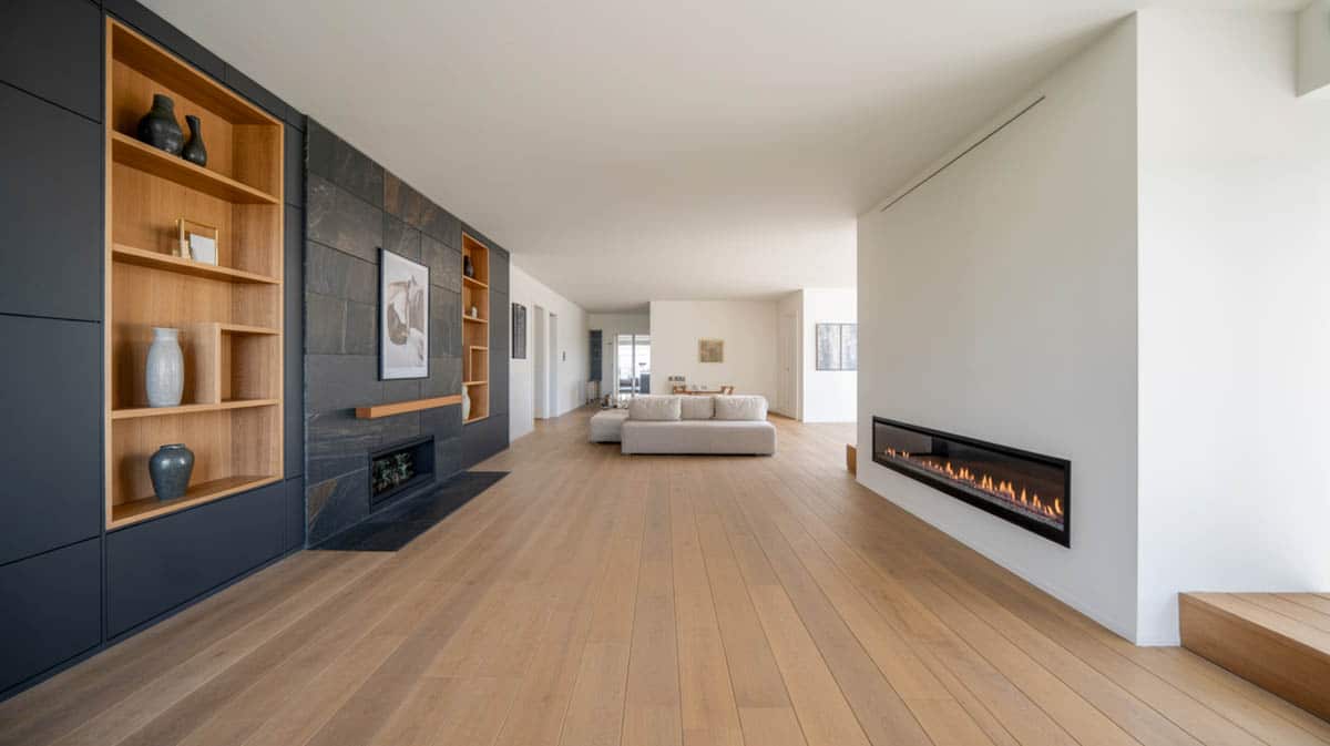 Spacious living room with charcoal slate-and-paint accent wall, modern fireplace, and wide-plank hardwood floor