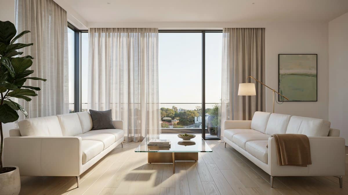 Two white leather sofas facing a glass coffee table by tall windows