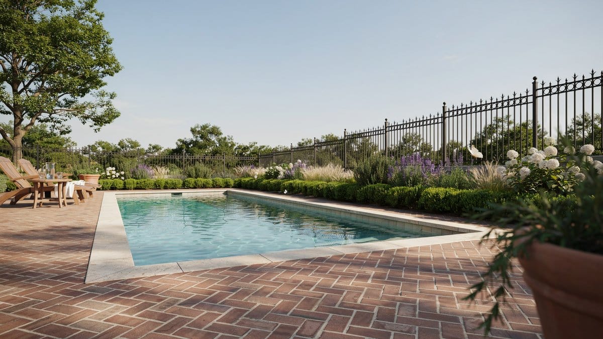 Decorative black wrought iron fence around a brick paver patio pool