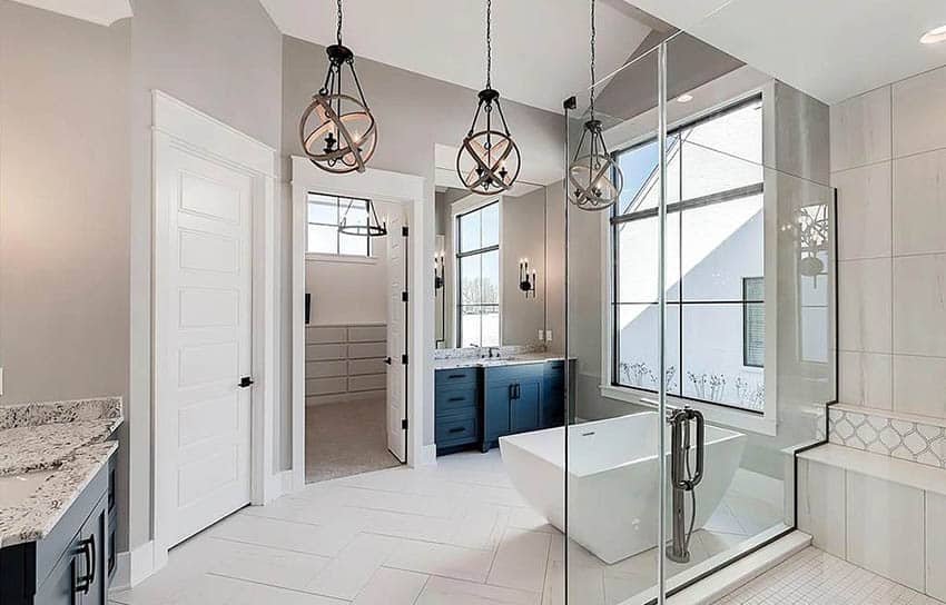 Beautiful master bathroom with gray wall paint, freestanding tub and globe chandeliers